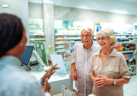 Pharmacist greeting a patient couple at the pharmacy counter